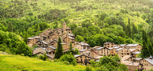 View of the rural village Os de Civís in the Catalan Pyrenees with the stone houses and green mountains behind - obrazy, fototapety, plakaty