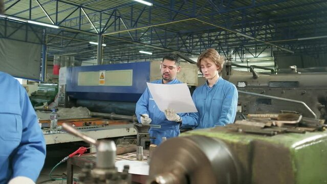 Professional industry workers teams in safety uniforms and engineers' partners worked with metalwork tools, discussed mechanical drawing for lathe machines, and workshops in manufacturing factory.