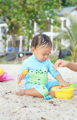 Child plays with sand at Koh Chang island, Thailand
