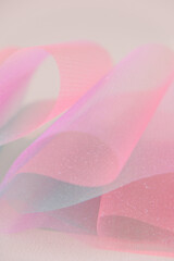 Fabric background.Wallpaper mauve phone.Tulle fabric.iridescent gradient texture.Shiny pink fabric with gradients. texture with iridescent folds.
