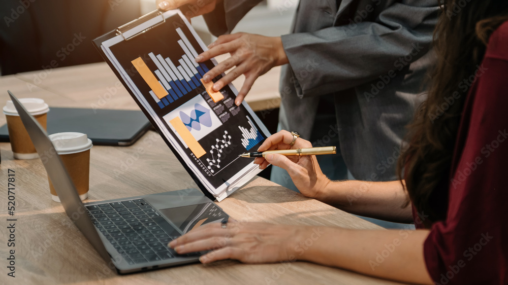 Poster bussinessman analyzing sales data and economic growth and pointing at business report document with 