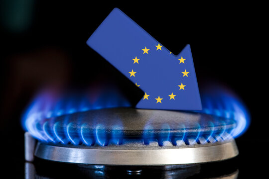 Decreased gas supplies in European Union. A gas stove with a burning flame and an arrow in the colors of the European Union flag pointing down. Concept of crisis in winter and lack of natural gas
