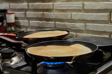 Fototapeta na wymiar Chef pan-frying Crepe Suzette pancakes with cognac and citrus sauce