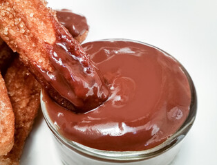 Delicious traditional churro dipped in liquid chocolate sauce fritter