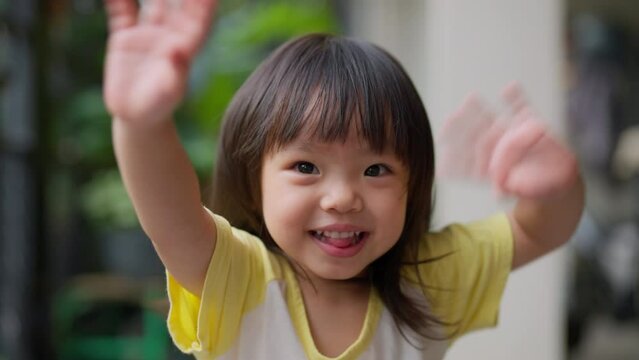 smiling happiness asian baby child girl sit relax at home say hi hand waving greeting to camera with cheerful laugh smile fun with energy of youth,cute girl smiling to camera
