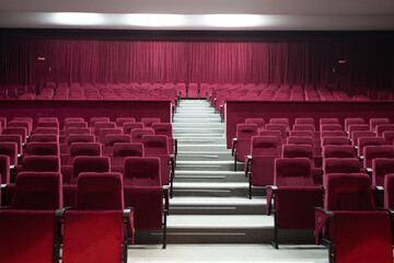 Empty red chairs for audience in the theater - obrazy, fototapety, plakaty