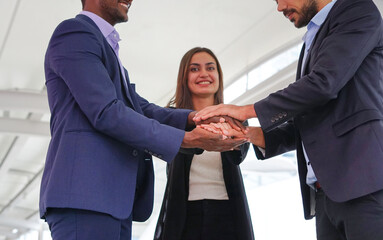 multiracial business people hands stacked for successful business, young happy business teamwork working outside building. selective focus at their hands