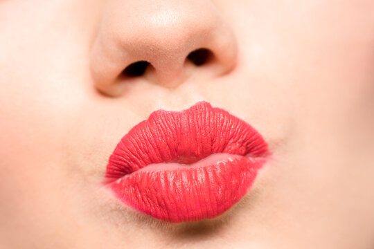 Woman's lips with red lipstick and kiss gesture.