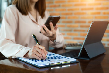 Bussinesswoman analyzing sales data and economic growth and pointing at business report document...