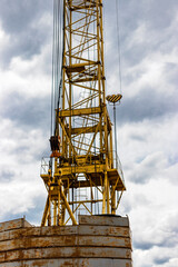 Fototapeta na wymiar Tower crane close-up against the background of the cloudy sky. Modern building technologies.