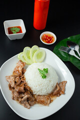 Stir-fried pork with garlic and pepper, and sliced cucumber served with jasmine rice, a white dish, a popular Thai dish