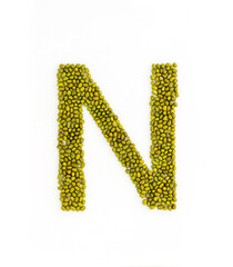 Capital letter N made from mung beans. Green mung bean font. Alphabet made from green gram . White background. Dry green maash seeds.