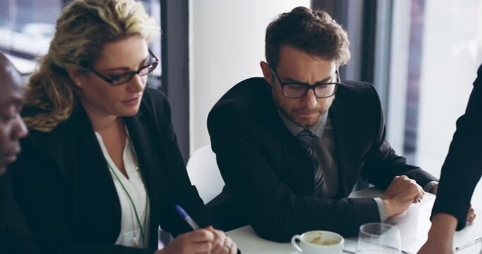 Professional businesspeople having a group meeting to come up with a strategy in the boardroom. Serious corporate colleagues working together in collaboration and planning their new office project