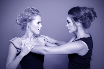 Fototapeta premium Two girls are fighting in the studio. Negative emotions.