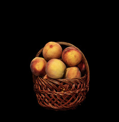  ripe peaches in a basket on a black background