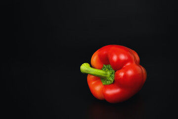 Fresh sweet red pepper on black background