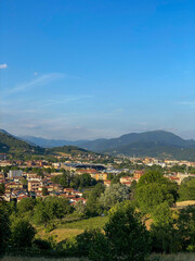 Fototapeta na wymiar Cityscape with green mountains in the background, Italy
