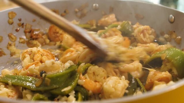 Slow motion shot cheese melting over shrimp, poblano peppers and garlic as they roast in a pan.  The ingredients let out their aromatic steam. Ingredients for gobernador tacos. Mexican food.