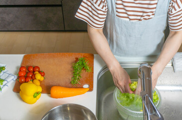 シンクでレタスを洗う主婦