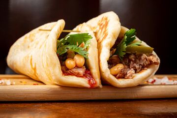 Mexican food quesadillas with chicken and cheese served on rustic wooden chopping board