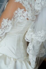 Fototapeta na wymiar Corset of the bride's wedding dress close-up, fabric with lace and clasp