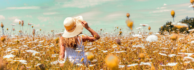 woman sitting in meadow with flowers ( freedom,  relax,  environment concept )
