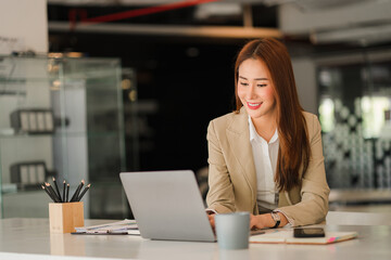 Obraz premium beautiful asian business woman Millennial professional female financial analyst working on financial charts and chart data with laptop in the office.