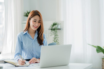 beautiful asian business woman Millennial professional female financial analyst working on financial charts and chart data with laptop in the office.