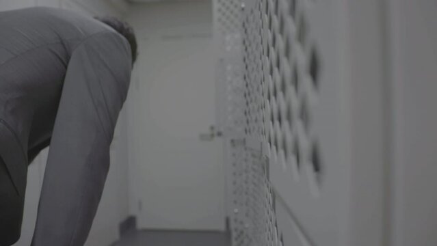 Close-up of an open white cabinet with a man closing it. Static view