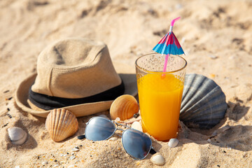 Fototapeta na wymiar fresh cocktail, sunglasses and hat on the beach
