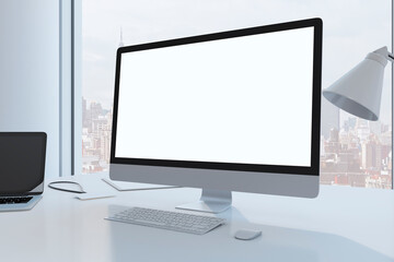 Close up of creative designer desktop with empty white mock up computer monitor laptop and supplies in modern office with window and panoramic city view. 3D Rendering.