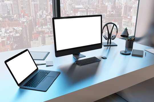 Close up of creative designer table with empty white mock up computer monitor laptop and supplies in modern office with window and panoramic city view. 3D Rendering.