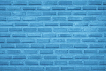 Brick wall painted with pale blue paint dark texture background. Brickwork interior pattern grid uneven bricks.