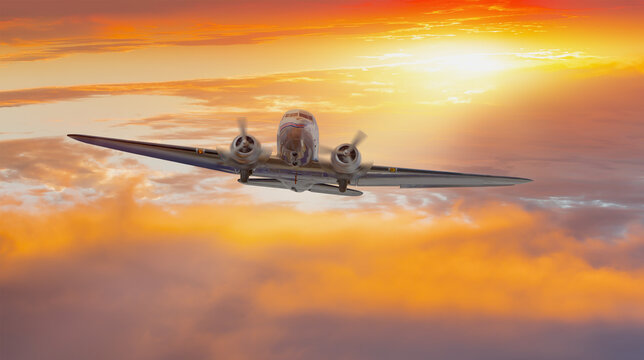 Old metallic propeller airplane in the sky, sunset clouds in the background