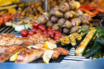 Assorted tasty grilled meat with vegetables over charcoal barbecue.