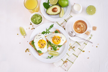 Fototapeta na wymiar healthy breakfast or snack - sliced avocado and fried egg on toasted bread and cup of coffee