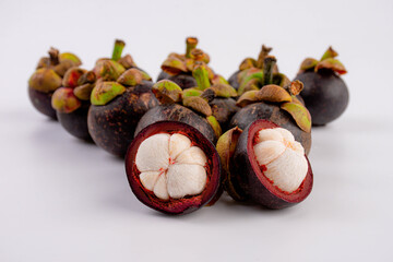Queen of Fruit in Thailand. Fresh mangosteen fruit and half mangosteen isolated on white background. Close-up 
