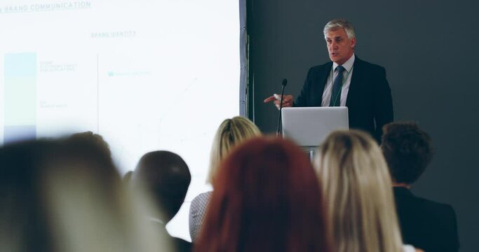 Education, training and learning business people at conference, presentation and office seminar. Confident mature manager, boss and ceo speaking, presenting and teaching diverse staff in workshop