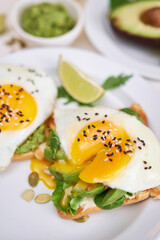 healthy breakfast or snack - sliced avocado and fried egg on toasted bread and cup of coffee