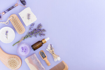 Lavender beaty and self-care products for body and skin care over purple background with copy space. Natural lavender cosmetics for beauty treatments, eco living concept. Flat lay style