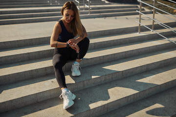 Sportswoman warming up before morning workout outdoors. Runner training on the waterfront, healthy lifestyle concept