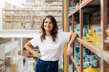 Cheerful ceramic store owner contemplating new creative ideas