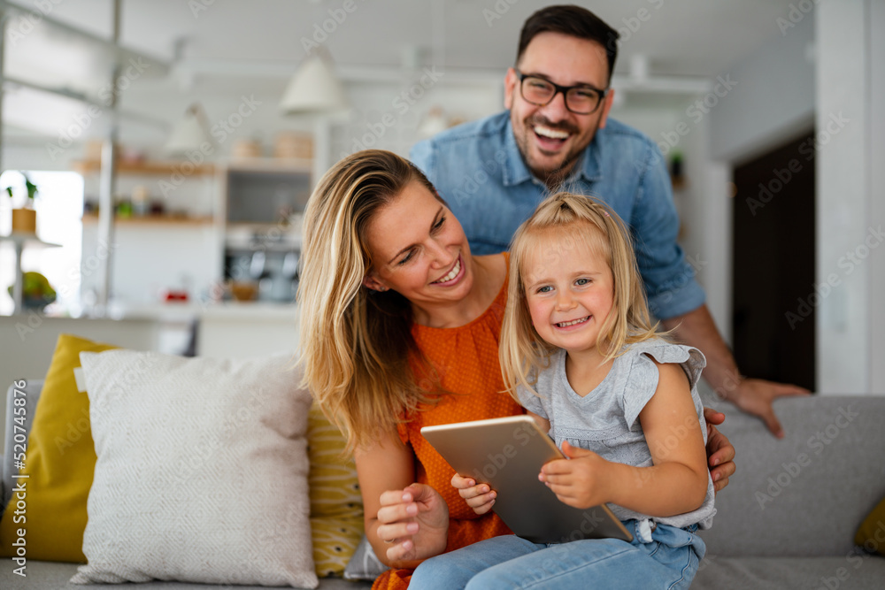 Wall mural Happy family spending time at home with digital devices together. Technology people fun concept.