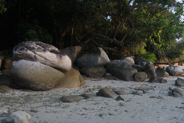 Naklejka na ściany i meble beautiful large stones on the sand with trees behind the rocks on berhala island
