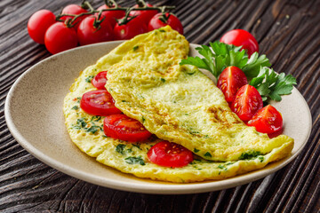 Omelet with dill filled tomatoes on a wooden background