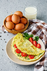 Omelet with dill sprinkled with pepper and filled tomatoes