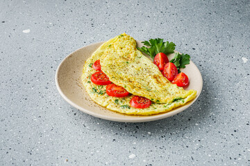 Omelet with dill sprinkled with pepper and filled tomatoes