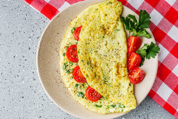 Omelet with dill sprinkled with pepper and filled tomatoes