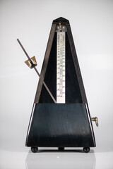Old metronome with swinging clock