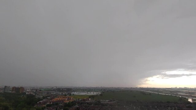 Rainy day timelapse, cloudy sky, lightining over the city view and green meadow